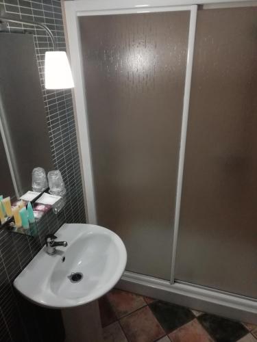 a bathroom with a sink and a shower at Hotel Montearoma in Valverde del Camino