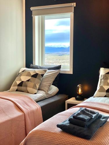 a bedroom with two beds and a window at Nátthagi Luxury Cottage in Snæfellsbær