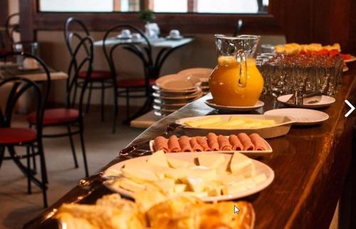 a table topped with plates of food and drinks at Estrada Real Palace Hotel in Brumadinho