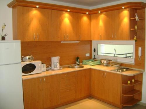 シオーフォクにあるPamela apartman Siófokのキッチン(木製キャビネット、白い冷蔵庫付)