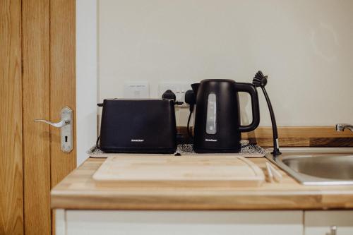 a black coffee maker sitting on a counter next to a sink at Betty's Loft in Lisburn