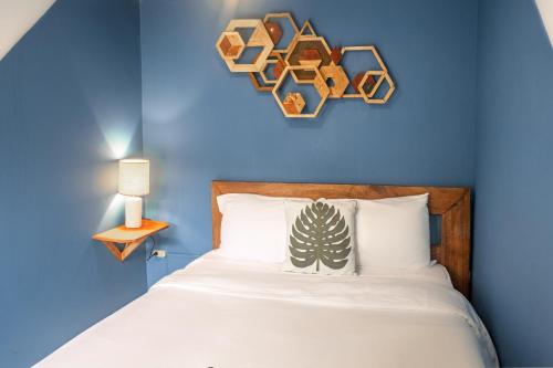 a bedroom with a bed with a blue wall at Selina Playa Venao in Playa Venao