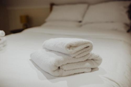 a pile of towels sitting on top of a bed at Betty's Loft in Lisburn