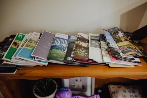 a pile of books sitting on top of a table at Betty's Loft in Lisburn