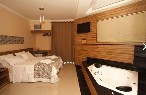 a bedroom with a bed and a bath tub at Estrada Real Palace Hotel in Brumadinho