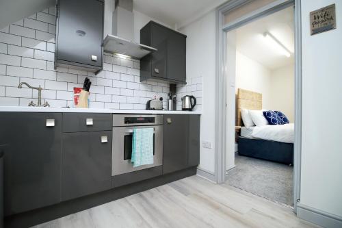 a kitchen with a sink and a stove top oven at 3BR Home with Parking in Swansea in Swansea