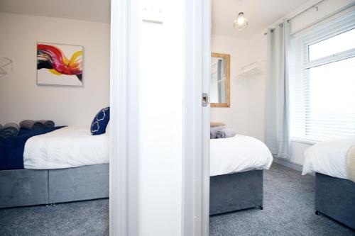 a bedroom with two beds and a window at 3BR Home with Parking in Swansea in Swansea