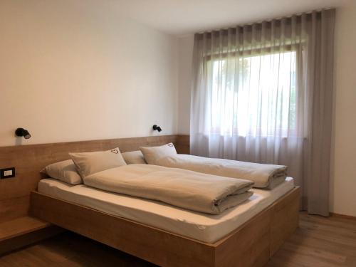 Bett in einem Zimmer mit Fenster in der Unterkunft Apartment42 in Brixen