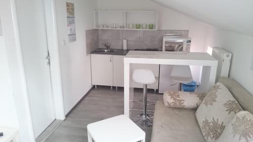a small kitchen with a couch and a table at Guest House Villa Herbarium in Slavonski Brod