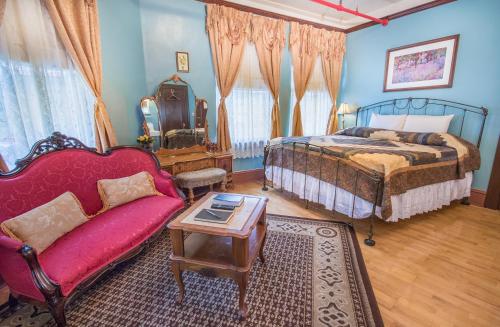 a bedroom with a bed and a couch and a table at The Edgewater Hotel in Orlando