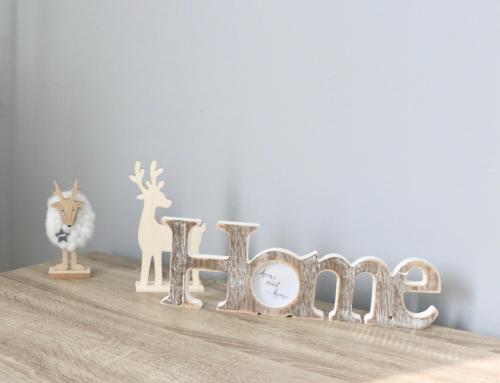 a wooden shelf with the word help next to a clock at Levendula Apartman Pécs in Pécs