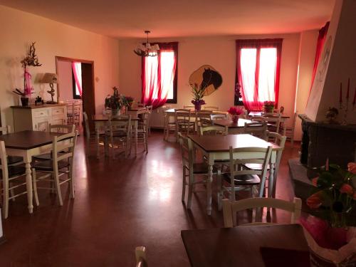 un comedor con mesas, sillas y cortinas rojas en Tenuta I Ginepri, en Ozzano dell'Emilia
