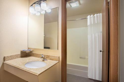 a bathroom with two sinks and a mirror at Travelodge by Wyndham Bozeman in Bozeman