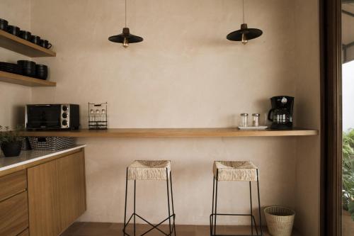 a kitchen with two stools at a counter at Casa Montore by Barrio Mexico in Guadalajara