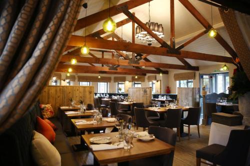 a dining room with wooden tables and chairs at The Royal Arms Hotel in Sutton Cheney