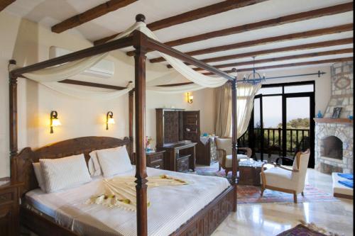 a bedroom with a canopy bed and a living room at Mandarin & Mango Boutique Hotel in Faralya
