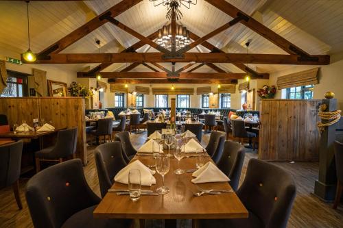 a dining room with a large wooden table and chairs at The Royal Arms Hotel in Sutton Cheney