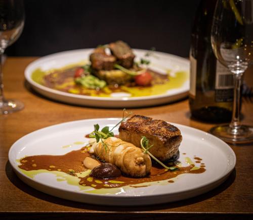 two plates of food on a wooden table at The Royal Arms Hotel in Sutton Cheney