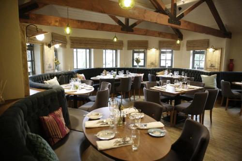 a restaurant with tables and chairs in a room at The Royal Arms Hotel in Sutton Cheney