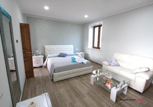 - un salon avec un lit et un canapé dans l'établissement VILLA IZZO B&B, à Bagnoli