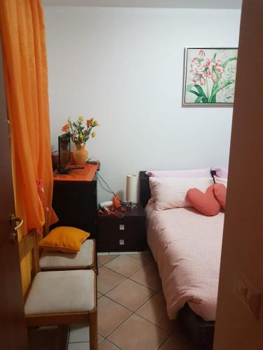 a bedroom with a bed and a chair in it at B&B Kristina in Quinto Vicentino
