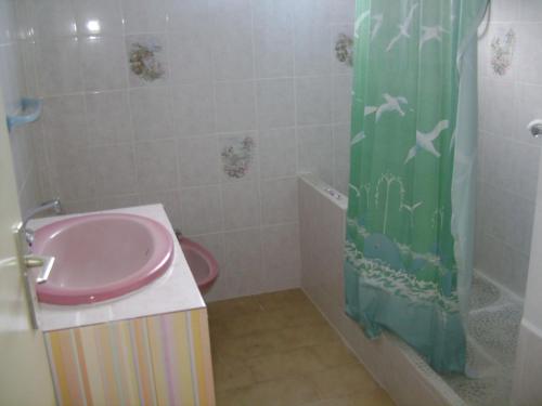 uma casa de banho com um lavatório e uma cortina de chuveiro em La Mirabelle em Le Vauclin