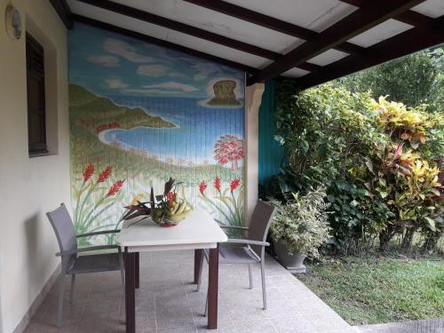 a table and two chairs in front of a painting at La Mirabelle in Le Vauclin