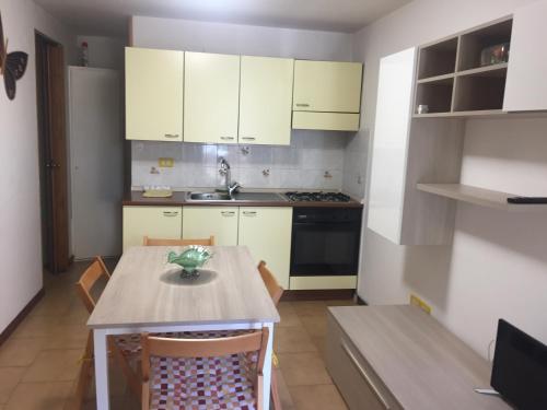 a kitchen with white cabinets and a table with chairs at due passi dal mare in San Benedetto del Tronto