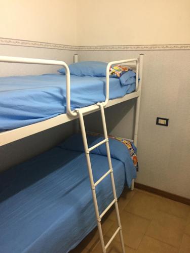 a bunk bed with a ladder next to two beds at due passi dal mare in San Benedetto del Tronto