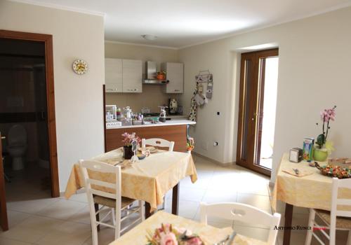a kitchen and living room with a table and chairs at VILLA IZZO B&B in Bagnoli