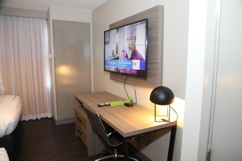 a room with a desk with a television on a wall at La Quinta by Wyndham Montgomery in Montgomery