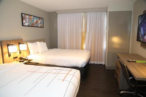 a hotel room with two beds and a desk at La Quinta by Wyndham Montgomery in Montgomery