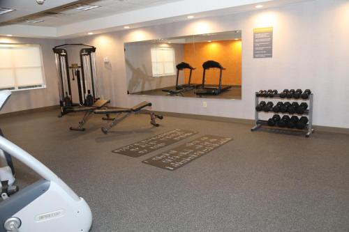 a gym with a mirror and several racks of weights at La Quinta by Wyndham Montgomery in Montgomery