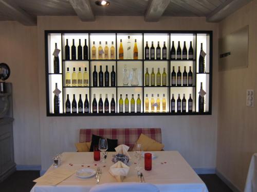 a table in a restaurant with a display of wine bottles at Landhotel Hirschen in Trüllikon