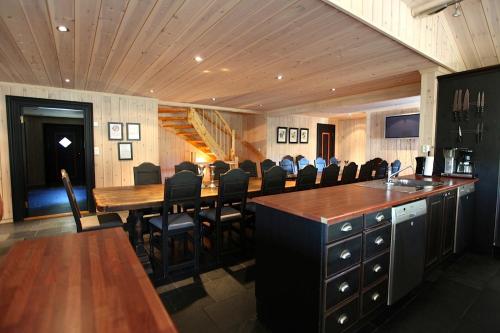 a restaurant with a long bar with black chairs at Kirkebøen Hytter in Hemsedal