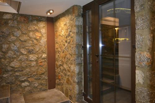 a hallway with a stone wall and a glass door at Port Villa in Ohrid