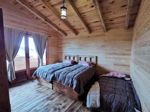 マサミトラにあるCABAÑAS COLINAS de SAN NICANORの丸太小屋のベッドが2つある寝室