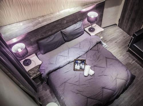台南的住宿－夏夜行館，一间卧室配有一张大紫色床和两盏灯