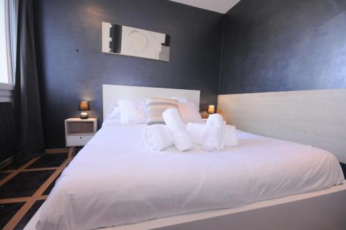1 dormitorio con 1 cama blanca grande con almohadas blancas en Le Grand Large - Apartment parking & balcony by the lake modern bright en Annecy