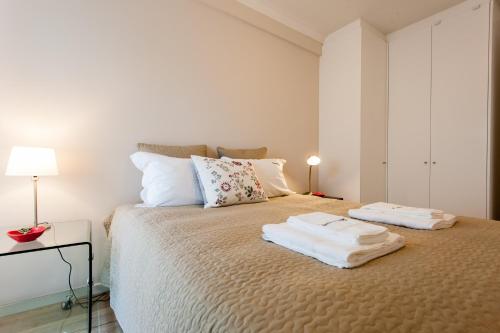 una camera da letto con un letto e due asciugamani di FLH Campo de Ourique Bright Apartment a Lisbona