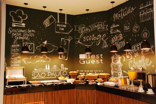 un restaurant avec un mur de tableau noir et des panneaux. dans l'établissement Best Guest Hotel Expo Anhembi, à São Paulo