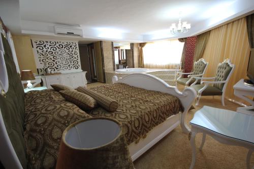 a bedroom with a bed and a bathroom with a tub at Grand Corner Boutique Hotel in İzmir