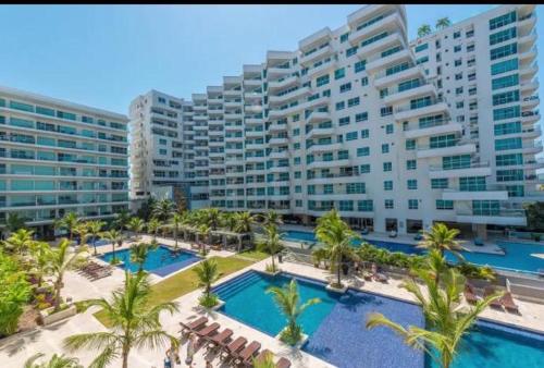a large apartment building with a pool and palm trees at Apartamento Morros Epic Cartagena in Cartagena de Indias