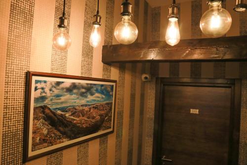 a hallway with a painting on the wall and lights at Pirocanac Hotel rooms & restaurant in Pirot