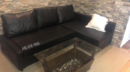a black leather couch in a living room at Apartamento con terraza y chimenea in La Rebollada