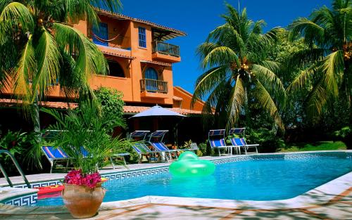 una piscina frente a un edificio con palmeras en Hotel Costa Linda Beach, en La Loma