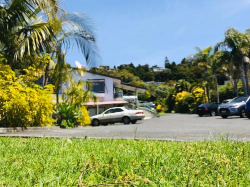 a parking lot with cars parked in front of a house at Bounty Motel in Paihia