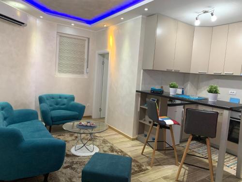 ein Wohnzimmer mit blauen Stühlen und eine Küche in der Unterkunft Apartmani Venera in Belgrad
