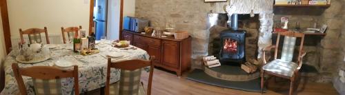 a kitchen with a table and a wood stove at Lower Turnerford Farmhouse in Newby