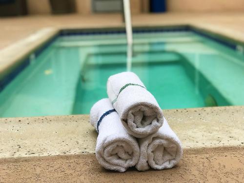 una toalla sentada en una cornisa junto a una piscina en The Pacific Inn, en Seal Beach